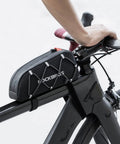Ride Ready Front Frame Bag For Bikes With Large Capacity Main Compartment, installed on top tube of black bike, hand on handlebars