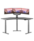 Top Tier Curved Electric Standing Desk With Quiet Dual Motors, Ultimate Triple Monitor Gaming Command Center with three monitors.