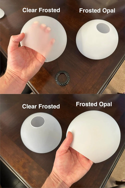 Person holding frosted opal and clear frosted glass globe, part of Three Pack Frosted Opal White Glass Globes Replacement For Light Fixtures 5.9 Inch Diameter 5 Inch Tall Soft White Round Lampshade Cover For Pendant Lights Wall Sconces And Chandeliers One And Five Eighth Inch Fitter E26 Bulb Compatible.