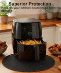 Air fryer on 20 Inch Round Tabletop Fire Pit Mat Pro Grade Heat Resistant Silicone Countertop Protector on kitchen counter.