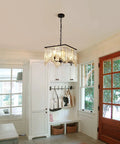 Four Light Crystal Chandelier With Black Iron Frame And K9 Clear Crystals hanging in hallway with wooden door and window.