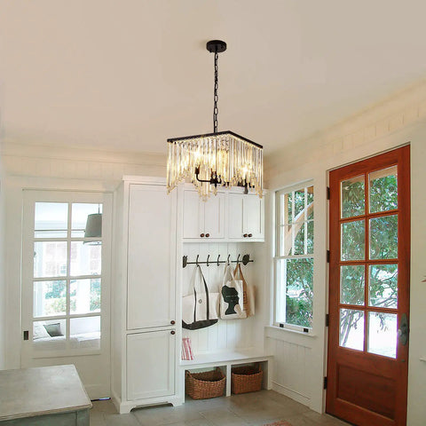 Four Light Crystal Chandelier With Black Iron Frame And K9 Clear Crystals hanging in hallway with wooden door and window.