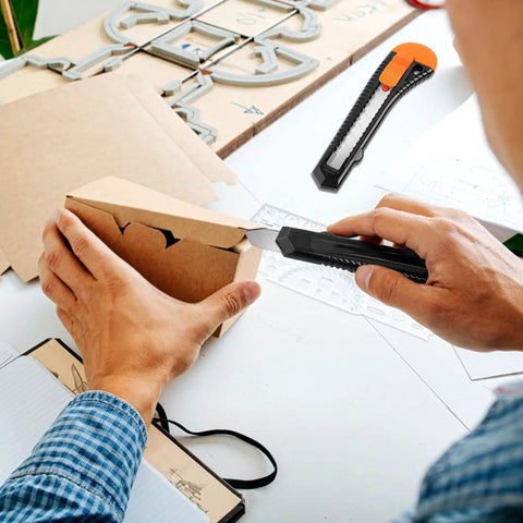 Person using 24 Pack Box Cutters With 18mm Snap Off Pro Grade Blades, Retractable Utility Knife Set for precise cutting on cardboard