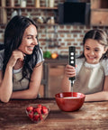 Child using 3-In-1 No-Fuss Rechargeable Milk Frother Handheld Foam Maker with a bowl on a kitchen counter