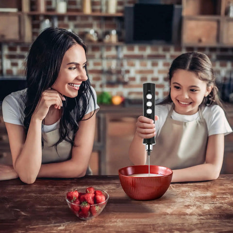 Child using 3-In-1 No-Fuss Rechargeable Milk Frother Handheld Foam Maker with a bowl on a kitchen counter