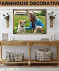 Farmhouse style living room with wooden console table, decorative wire baskets, vases, and framed photo of woman and dog in field.