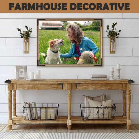 Farmhouse style living room with wooden console table, decorative wire baskets, vases, and framed photo of woman and dog in field.