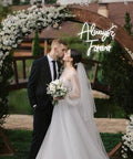 Elegant wedding scene with couple under floral arch and 'Always & Forever' neon sign, white LED light.