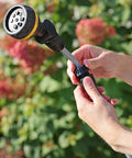 Hands adjusting RelaxGrip No Sweat Eight Pattern Pivoting Head Watering Wand With Quick Connect Extension in garden setting.