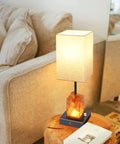 Touch Table Lamp With USB Ports And Himalayan Salt Nightstand Light on a wooden table beside a sofa in a living room setting.