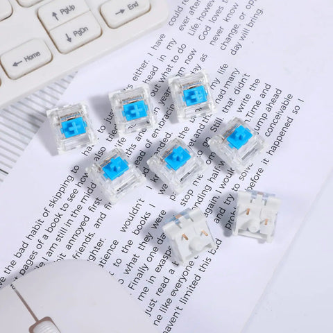 Blue 3 Pin Pre Lubricated Clicky Mechanical Keyboard Switches scattered on paper