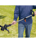 Person using 40V Max String Trimmer And Lawn Edger With 13 Inch Cutting Swath And Far Reach For Easy Edging And Weed Removal Battery And Charger Not Included Lightweight Power Tool For Quick Yard Cleanup in a garden