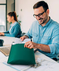 Man using Green Bubble Mailers 12x16 Inch 40 Pack Padded Envelopes With 12x15 Inch Usable Size at office, sealing shipping documents.