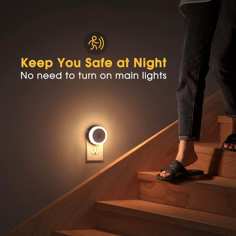 4 Pack Plug In LED Night Lights With Light Sensor Auto On At Dusk For Kids Room And Nursery Kid Friendly Night Lights Also Ideal For Bathroom Hallway And Staircase Compact Wall Outlet Friendly Design Warm White Glow. Image shows a glowing night light in a staircase.