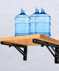 Legit Heavy Duty Black Folding Shelf Brackets Wall Mount Supports Rock Solid 150 Lb Load Capacity Pack Of Two holding wooden shelf with water bottles.