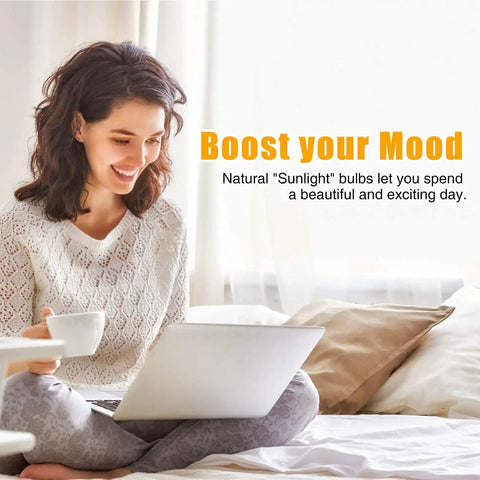 Woman smiling with laptop and coffee cup under "Boost Your Mood" text, promoting Natural Sunlight LED Bulbs 6000K Full Spectrum A19.