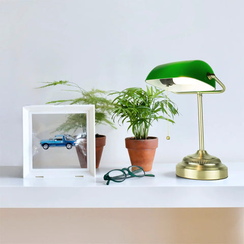 Morgan Antique Green LED Bankers Desk Lamp With Adjustable Arm alongside plants and decor on a white shelf.