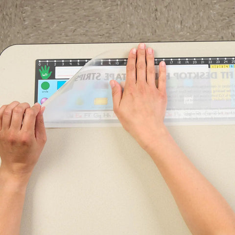 Applying EZ-Fit Desktop Helper Tape Strips Pack of 36 Student Desk Name Tags for organization on classroom desk