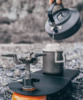 Featherweight Ultralight Folding Camp Table for Solo Camping and Backpacking with stove and kettle setup, black aluminum.