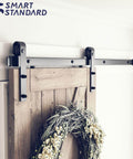 Heavy Duty 5ft Sliding Barn Door Hardware Kit With Track Kit, Pull Handle Set, And Floor Guide, shown installed on wooden door