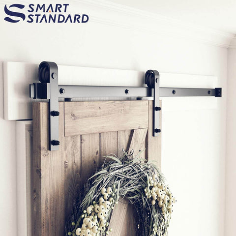 Heavy Duty 5ft Sliding Barn Door Hardware Kit With Track Kit, Pull Handle Set, And Floor Guide, shown installed on wooden door