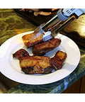 Pro Culinary Torch With Adjustable Flame Up To 2700 F torching meat on a white plate; one touch ignition in use