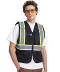 Custom Printed High Visibility Safety Vest With Wide Reflective Tape And Matte Black Build Designed For Hard Working Teams Wanting A Dope Fresh Edge On The Job, worn by a model with safety glasses.