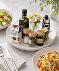 Super Smooth Spinning Ceramic Lazy Susan Tray With Natural Acacia Wood Base Round Rotating Kitchen Counter Organizer and Farmhouse Condiment Holder used with salad and pasta dishes.