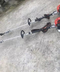 Two heavy duty 4 stroke tree hook grass cutter scythes sickles with 1.7 meter steel blade for lawn weed clearing, on concrete ground