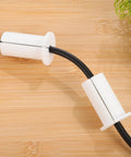 Two Pack Silky Soft Silicone Wall Cable Grommets Kit With Removable Design For Gaming Setups And Entertainment Units To Keep Wires Protected From Fraying And Damage In Sleek White Style, two white silicone cable grommets on black cord