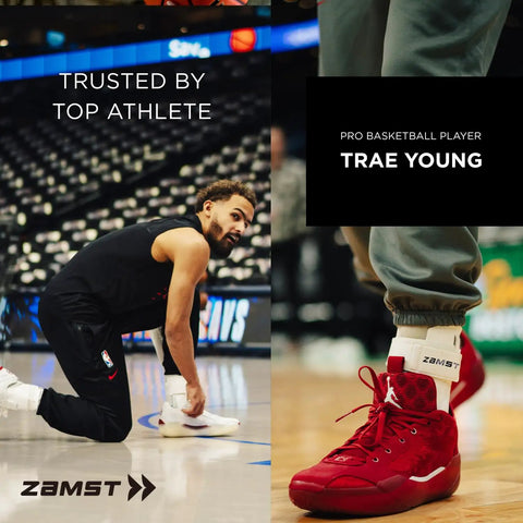 Basketball player kneeling on court wearing white ankle brace, Zamst logo visible.