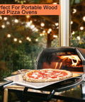 Person using portable wood-fired pizza oven with pizza, ideal for Kiln Dried Oak Pizza Oven Wood Logs Barkless Six Inch About Twelve Pounds Premium Firewood For Wood Fired Ovens And Grills Ideal For Weekend Grillers And Pros Like Ooni Gozney Solo Stove And Other Smokers Delivers Rich Smoky Flavor And Even Heat.