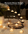 24 Pack Flameless LED Tea Lights Battery Operated Warm White Flickering Mini Candles For Christmas Decor Safe Smokeless Realistic Look For Mantel, Tables, Weddings And Home Ambience No Open Flame displayed on a decorative stand with petals.