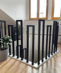 Floor Mounted U Shaped Stair Handrail Matte Black Heavy Duty Iron Railing Indoor Outdoor Steps with plants in background.