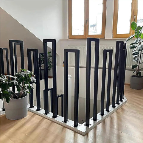 Floor Mounted U Shaped Stair Handrail Matte Black Heavy Duty Iron Railing Indoor Outdoor Steps with plants in background.