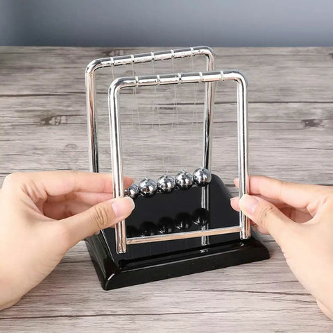 Five Ball Newton's Cradle Desktop Toy For Office And Home Decor With Black Wood Base And Strong Nylon String, hands adjusting