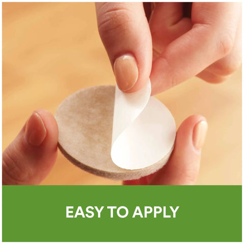 Close-up of hands peeling adhesive backing from Beige 32 Piece Round One Inch Felt Furniture Pads With Self Stick Adhesive Protect Hardwood Floors From Nicks Dents And Scratches While Moving Furniture Like A Pro, showing easy application.