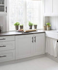 Modern kitchen with 20 Pack Oil Rubbed Bronze Solid Cabinet Handles Drawer Pulls 5.38 Inches Long, sleek white cabinetry.