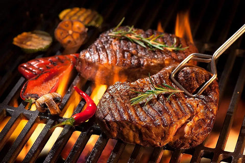 Juicy steaks and vegetables grilling over flames, highlighting Grill Replacement Parts Kit With Heat Plate Shield And Igniter.