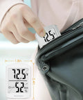 Person placing Smart Indoor Hygrometer Digital Thermometer with Quick 3 Second Refresh into a bag, showing size dimensions.