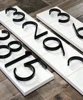 5-inch black stainless steel house numbers with nail mounting kit on white rectangular boards