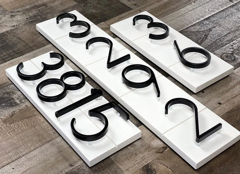 5-inch black stainless steel house numbers with nail mounting kit on white rectangular boards