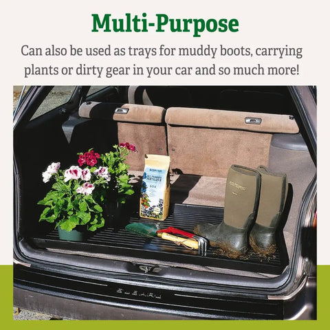 Large Plant Tray Workhorse For Indoor And Outdoor Gardening in car trunk with plants, potting materials, and boots, black tray.