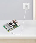 Raspberry Pi 5 Starter Kit With 4GB RAM, 27W PD Power Supply, Active Cooler on a table with USB-C cable plugged in