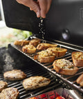 Genesis E 325 Liquid Propane Gas Grill For Outdoor Cooking With Three Burners Black Porcelain Enameled Cast Iron Grates in use