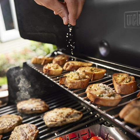 Genesis E 325 Liquid Propane Gas Grill For Outdoor Cooking With Three Burners Black Porcelain Enameled Cast Iron Grates in use
