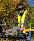 Worker using saw wearing tinted safety goggles with anti fog lens for pro grade eye protection, scratch resistant UV shield