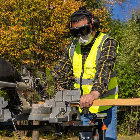 Worker using saw wearing tinted safety goggles with anti fog lens for pro grade eye protection, scratch resistant UV shield