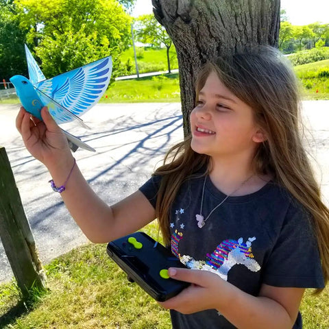 Child holding Rad Flying RC Bird Toy For Kids With Realistic Flapping Wings And USB Recharge 2.4GHz Remote Control Outdoor