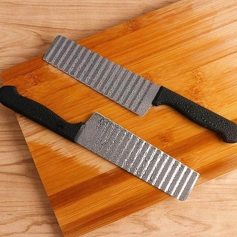 Two-piece stainless steel potato slicers with crinkle blades and black handles on a wooden cutting board
